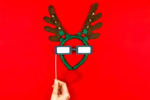 Woman's hand making flat designed funny decorating Santa's Christmas deer wit Stock Photos