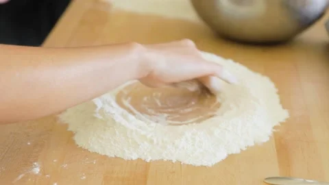 Woman's hand making flour well for pasta cooking class Stock Footage 199152202