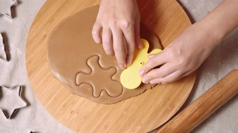 Woman's hand making a gingerbread cookie in the form of gingerbread man. Stock-Footage 143218396