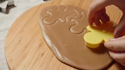 Woman's hand making a gingerbread cookie in the form of gingerbread man Stock Footage 143711814