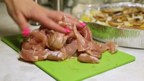 A woman's hand marinates meat with spices on a green kitchen Board Stock Footage 139913736