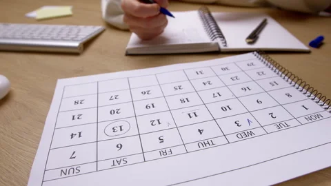 A woman's hand marks a day, date, or deadline on a calendar. Time management.  Stock Footage 325601308