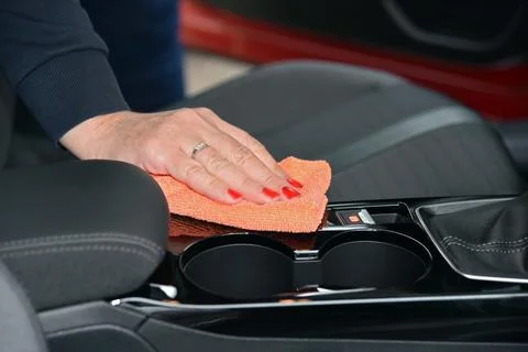 Woman's hand with microfiber cloth cleaning car console Stock Photos