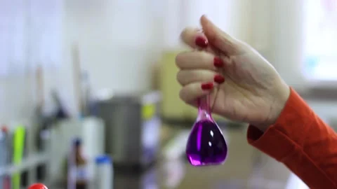 A woman's hand mixes ingredients of different compositions in a test tube Stock Footage 221363375