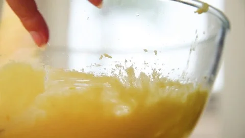 Woman's hand mixing orange cake batter in kitchen Vídeos de archivo 76099604