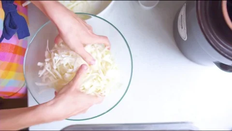 Woman's hand mixing raw cabbage in a glass bowl Video stock 76140040