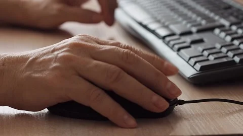 Woman's hand moves a computer mouse while working at a computer Stock Footage 237516795