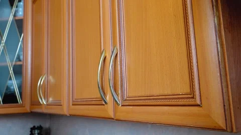 Woman's hand opening and closing wooden kitchen cabinet door Stock Footage 323948827