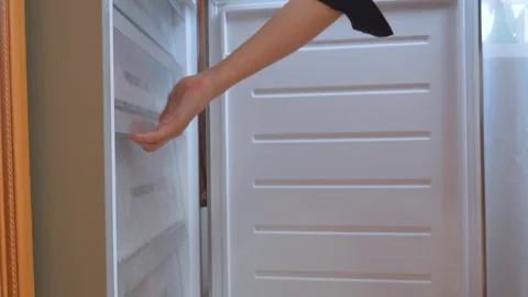 Woman's hand opening and closing freezer drawer Stock Footage 323948831