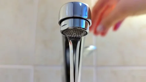 A woman's hand opens and closes the kitchen metal shiny water tap. Stock Footage 165178665