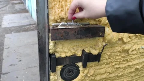 A womans hand opens, closes an old metal latch on the door close-up. Spindle for Stock Footage 322733276