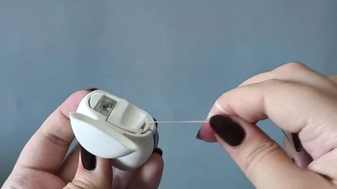 A womans hand opens the container and pulls the dental floss out of the Stock-Footage 329969556