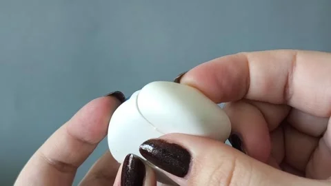 A womans hand opens the container and pulls the dental floss out of the 库存影片 329969558