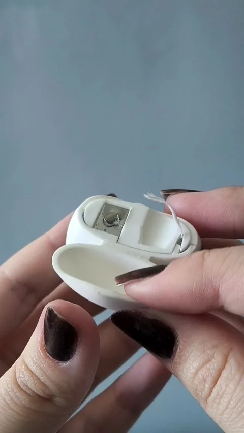 A womans hand opens the container and pulls the dental floss out of the 库存影片 329969574