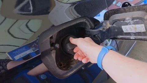 Woman's hand opens a dusty car fuel door and unscrews the gas cap. 库存影片 342065408