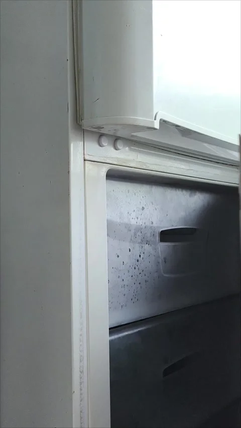A womans hand opens the freezer door in the refrigerator and pulls out a Video stock 313834063