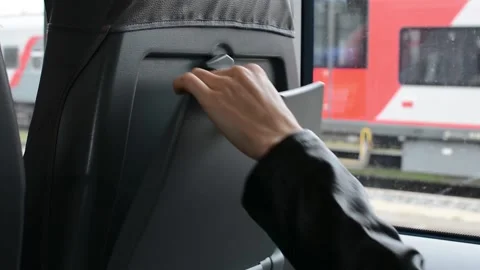 Woman's hand opens the latch a folding seat table in a city train Stock Footage 141305957