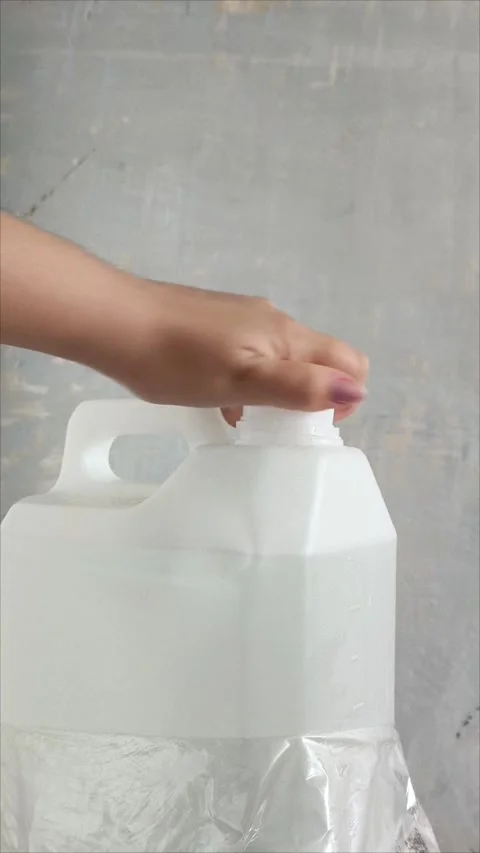 A womans hand opens the lid of a white plastic canister on the background of a Stock Footage 313834498