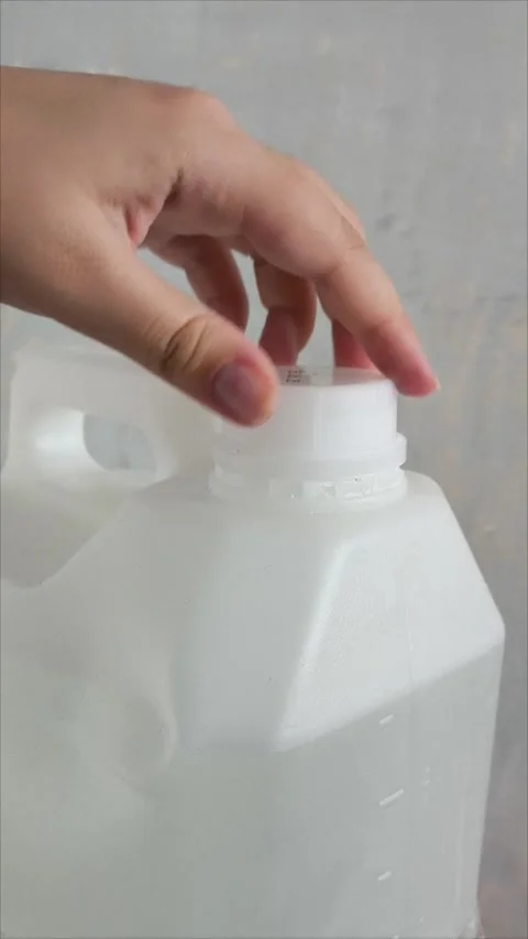 A womans hand opens the lid of a white plastic canister on the background of a Stock Footage 313834507