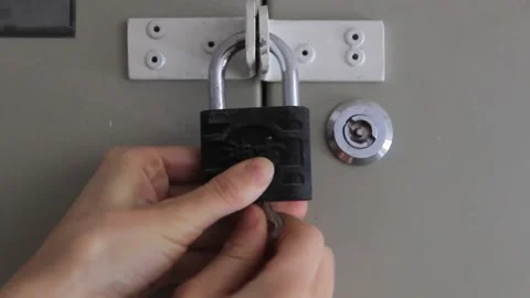 Woman's hand opens the lock with a key on the shield close-up. Stock Footage 169800034