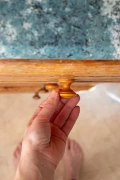 Woman's hand opens old kitchen drawer in kitchen at home top down view Stock Photos