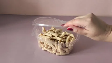 A womans hand opens a plastic container with crispbread. The benefits of whole Stock Footage 324770023