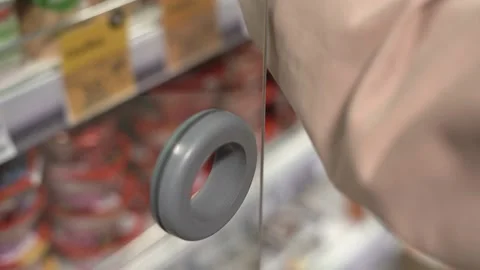 A woman's hand opens the refrigerator door in the store Stock Footage 182032160
