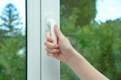 A woman's hand opens the sash of the window. Close-up. Stock Photos