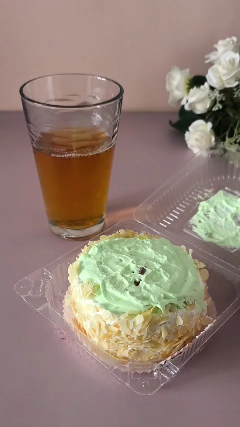 A womans hand opens a transparent plastic container with a pie with cream and Stock Footage 324697872