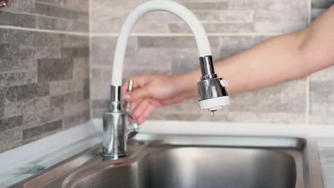 A womans hand opens the water in the kitchen faucet Stock Footage 304945347
