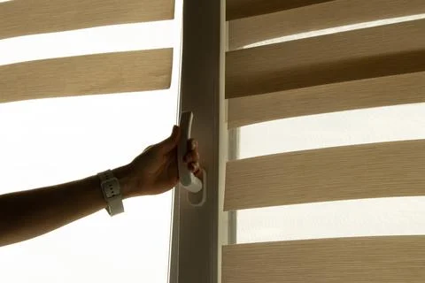 A woman's hand opens a window in an apartment to ventilate Stock Photos