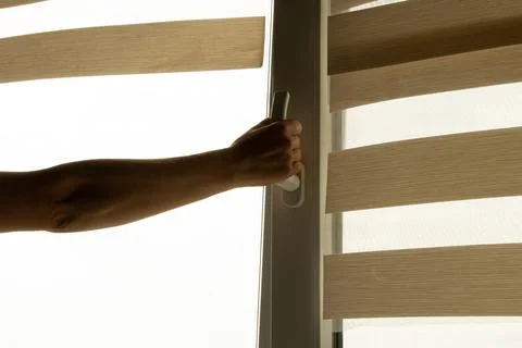 A woman's hand opens a window in an apartment to ventilate Stock Photos