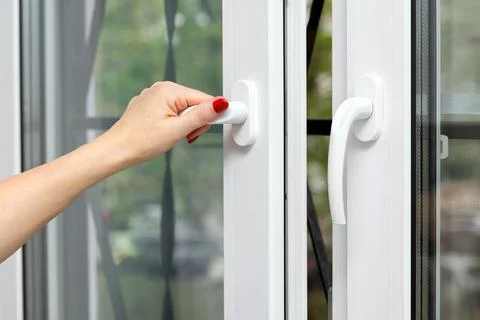 A woman's hand opens a window, close-up. 스톡 사진