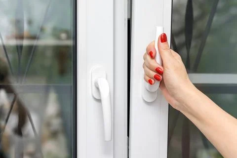 A woman's hand opens a window. Foto stock
