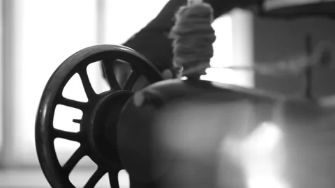 Woman's hand operates an old sewing machine, turning its handle Stock Footage 237724485