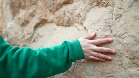 Woman's hand passing through the stone of a cliff Stock Footage 262962732
