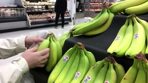 Woman's hand picking bananas inside Walmart store with 4k resolution Video stock 72251275