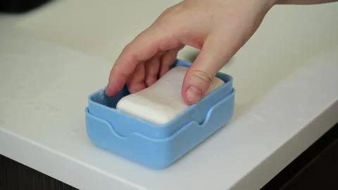 Woman's hand picking up bar soap from dish Stock Footage 329199784