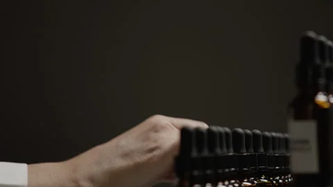 A woman's hand is picking different small bottles and choosing Stock Footage 271538772