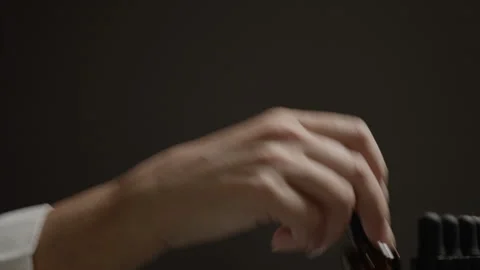 A woman's hand is picking different small bottles and choosing Stock Footage 271541100