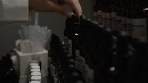 A woman's hand is picking different small bottles and choosing Stock Footage 271542208