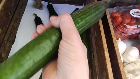 Woman's hand picking up a  fresh cucumber Stock Footage 306573167