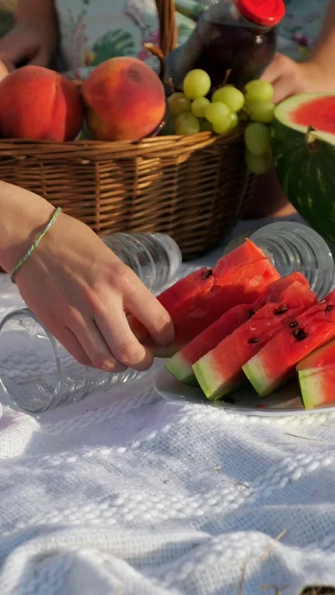 Womans hand picking a juicy watermelon slice during a summer picnic with fresh Video stock 341428792
