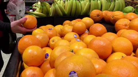 Woman's hand picking orange inside Save on foods store Stock Footage