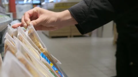 A woman's hand picks up and selects sandwiches in a grocery store. Stock Footage 281912013