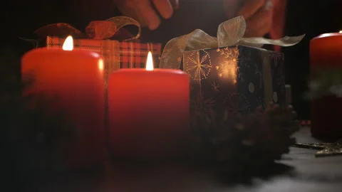 A woman's hand picks up a gift on the table decorated with Christmas decorations Stock Footage 144936566