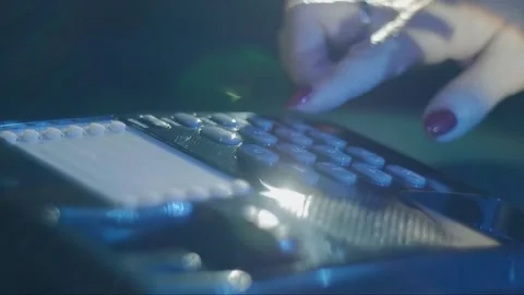Woman's hand picks up the receiver of a black shiny push-button old telephone Stock Footage 287932724