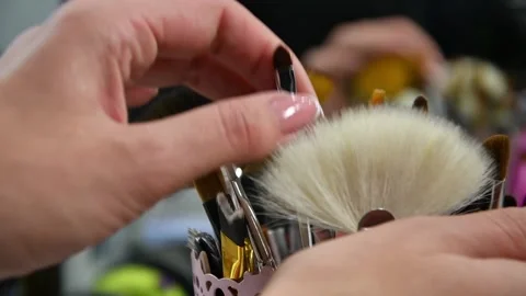 A woman's hand picks up a small makeup brush from the table in a beauty salon, Video stock 143505203