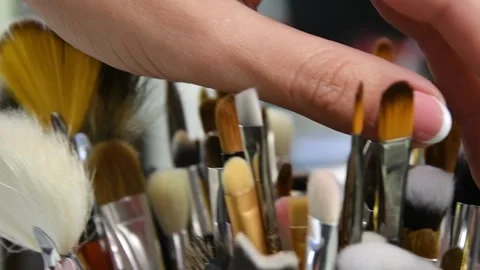 A woman's hand picks up a small makeup brush from the table in a beauty salon, Video stock 143505650