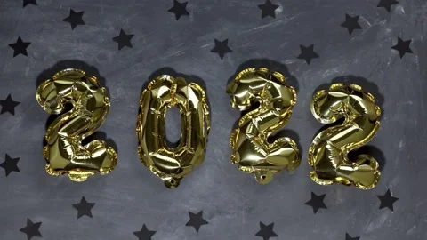 A woman's hand placed the number 2 in the inscription 2022, from balloons Stock Footage 168415766